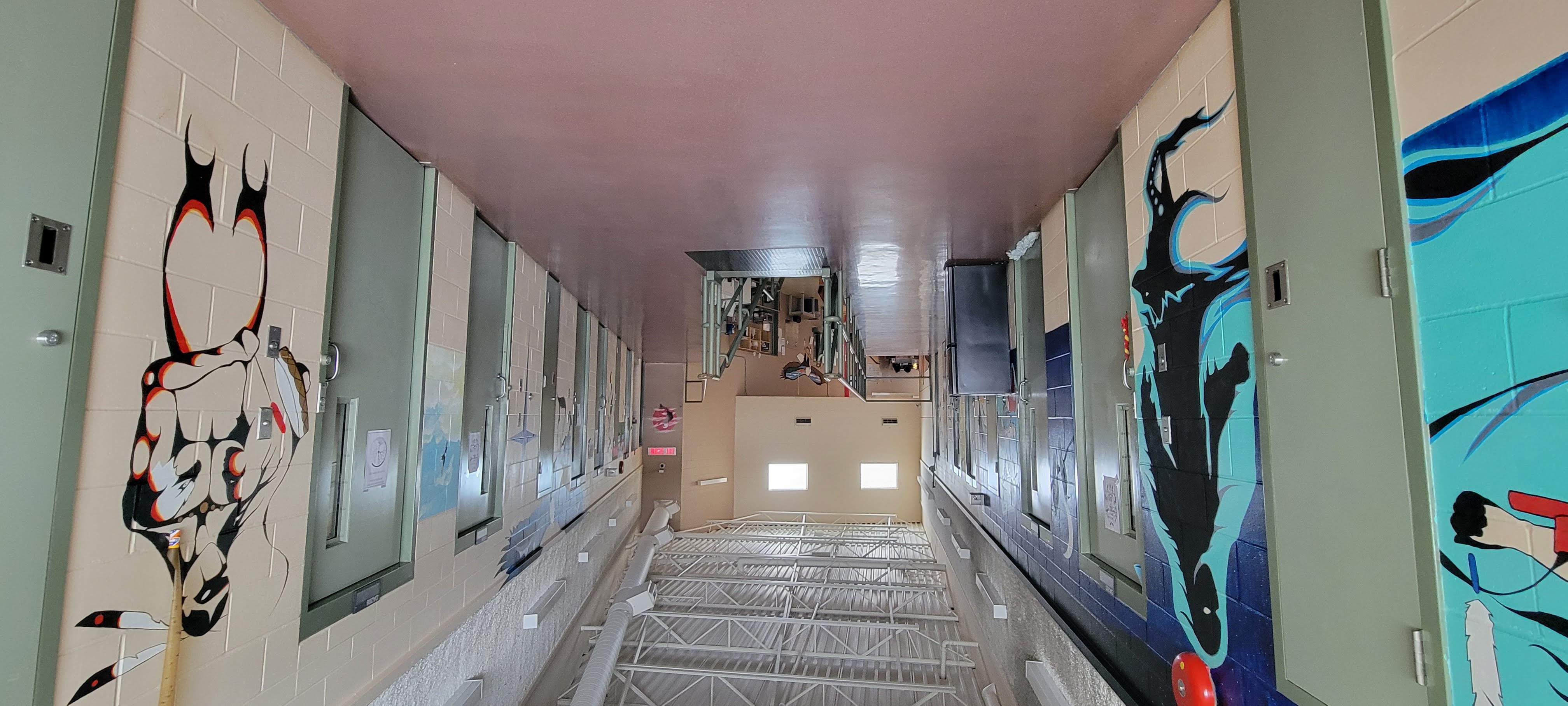 Photo of a range with Indigenous murals on the walls between cell doors at Pacific Institution.