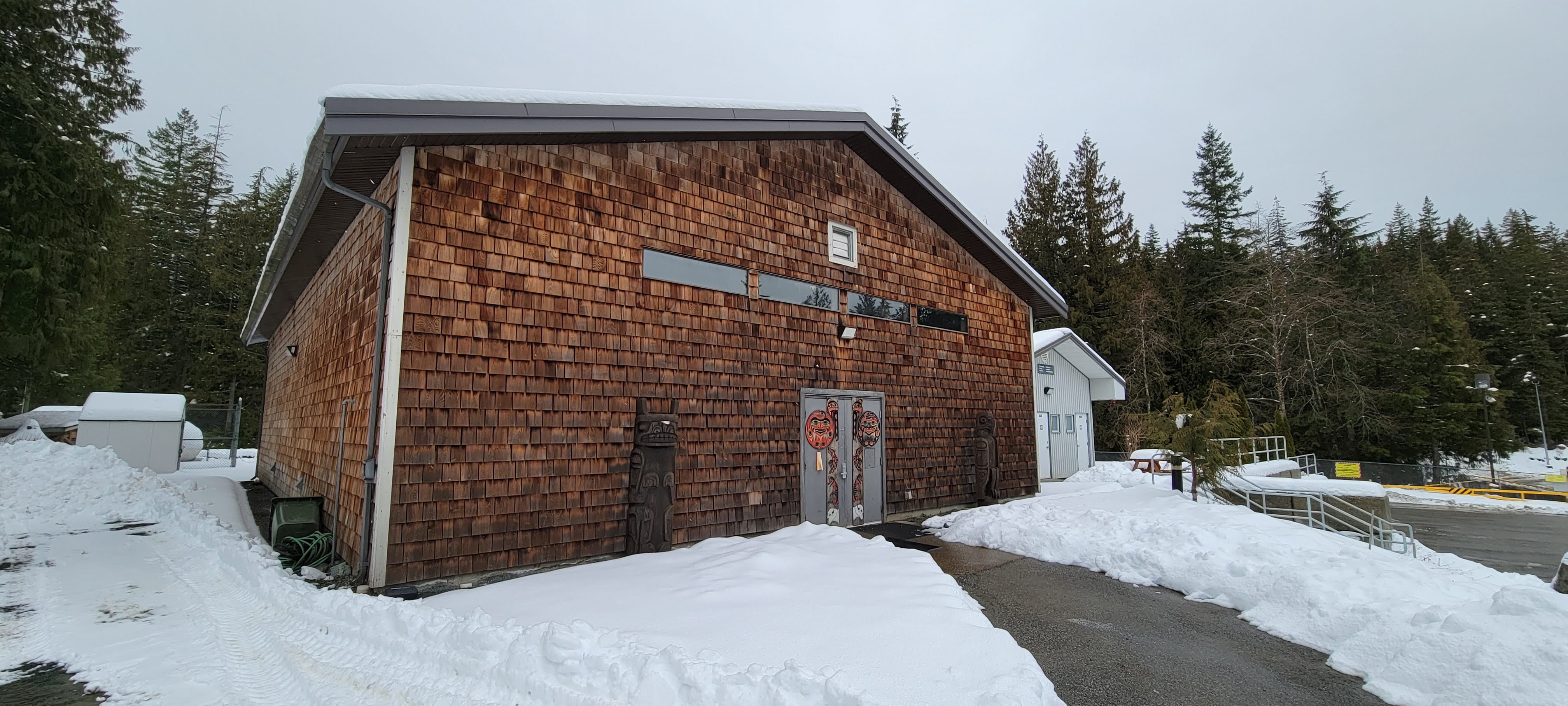 Photo of the exterior of the longhouse at Kwìkwèxwelhp Healing Village.